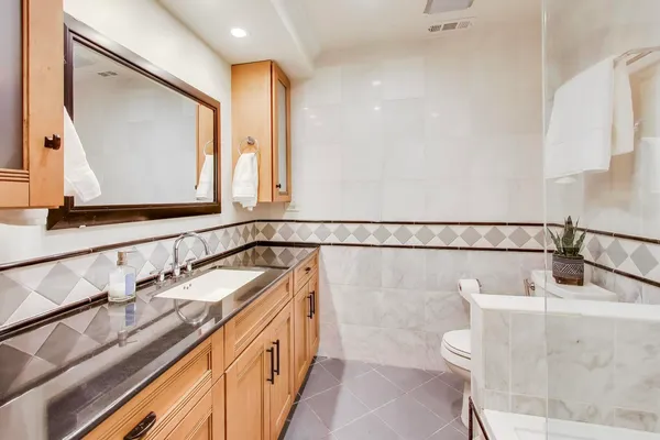 a bathroom with a sink a toilet and mirror