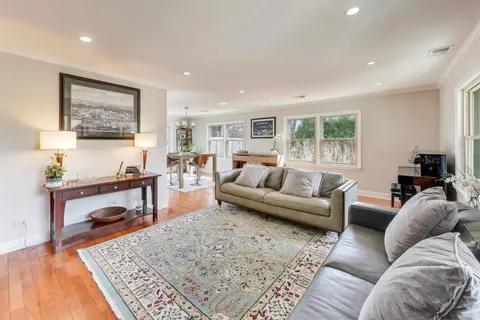 a living room with furniture a rug and a table