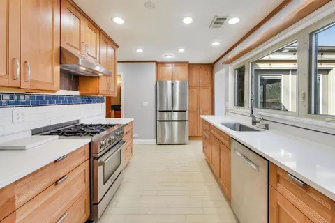 a kitchen with stainless steel appliances granite countertop a sink stove and refrigerator