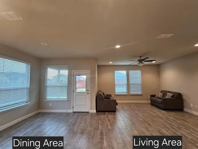 a view of a hall with wooden floor and windows