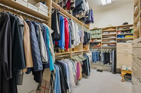 a view of walk in closet with clothes and shoes