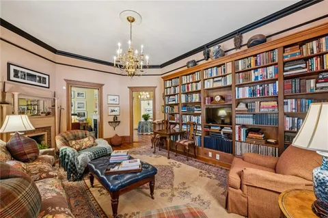 a living room with furniture a bookshelf and a chandelier