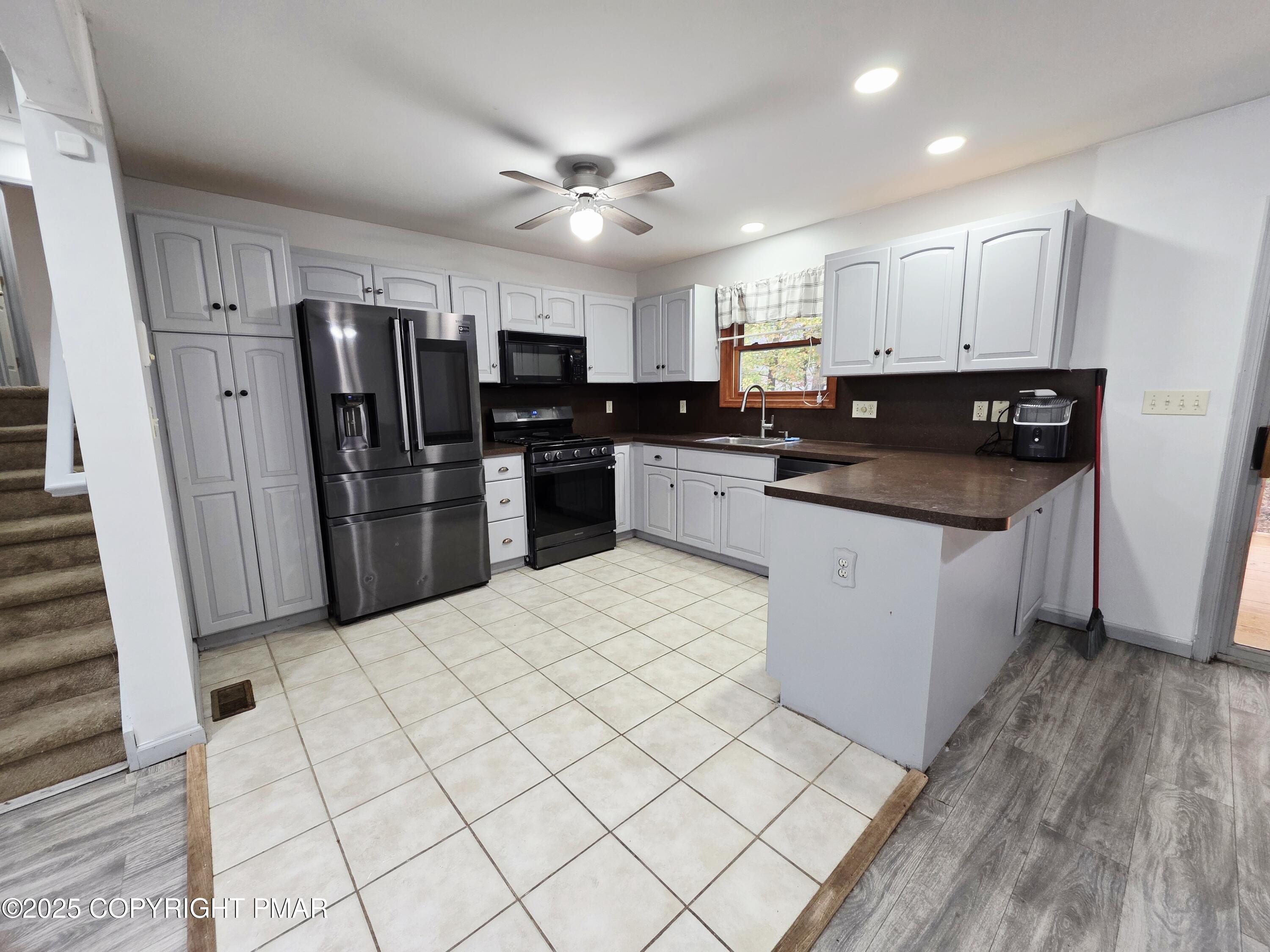 1001 Long Lake Road Tamiment, PA 18371 - Photo 11 of 38 a kitchen with stainless steel appliances kitchen island granite countertop a refrigerator and a sink