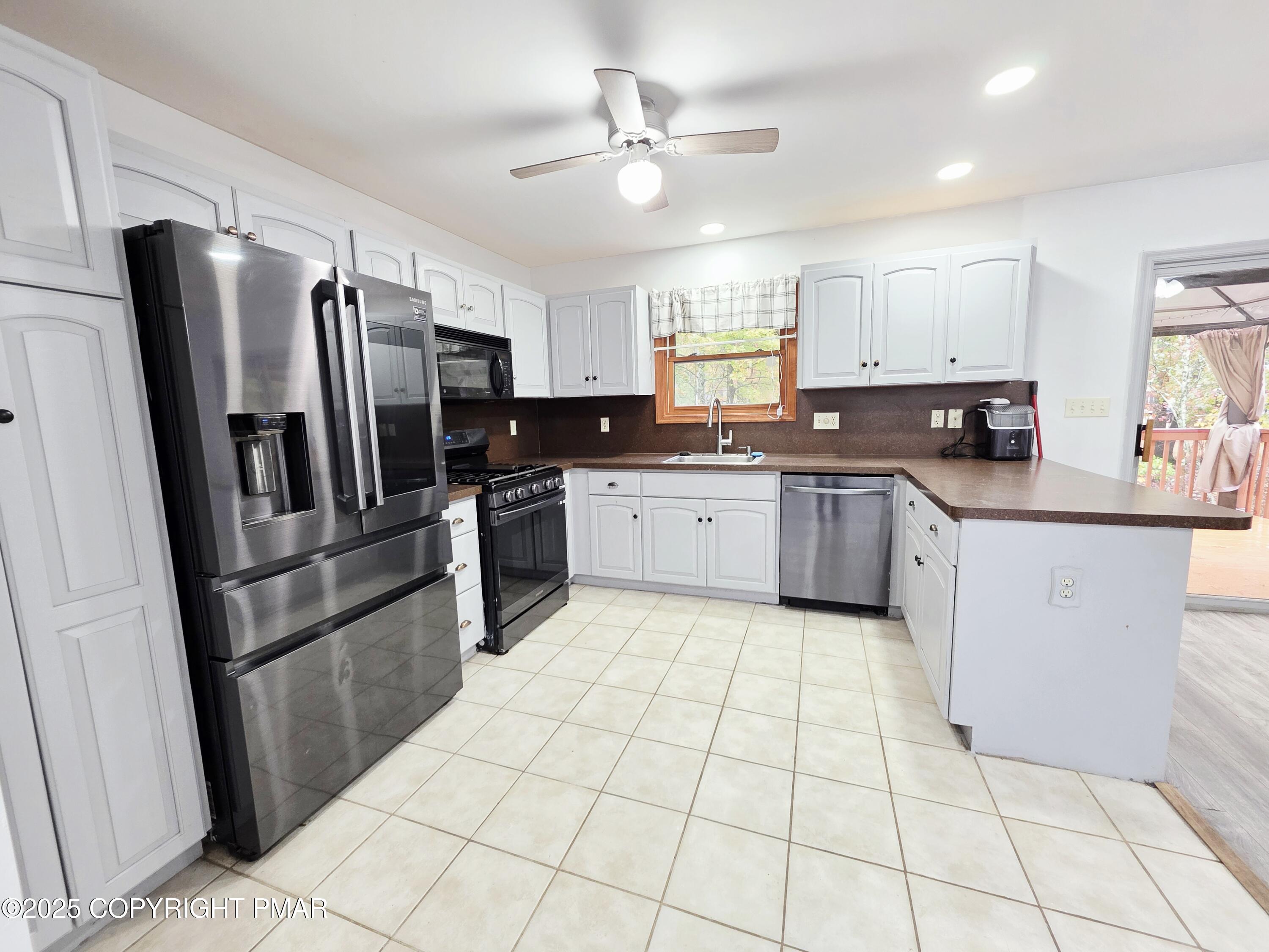 1001 Long Lake Road Tamiment, PA 18371 - Photo 12 of 38 a kitchen with stainless steel appliances granite countertop a sink stove and refrigerator