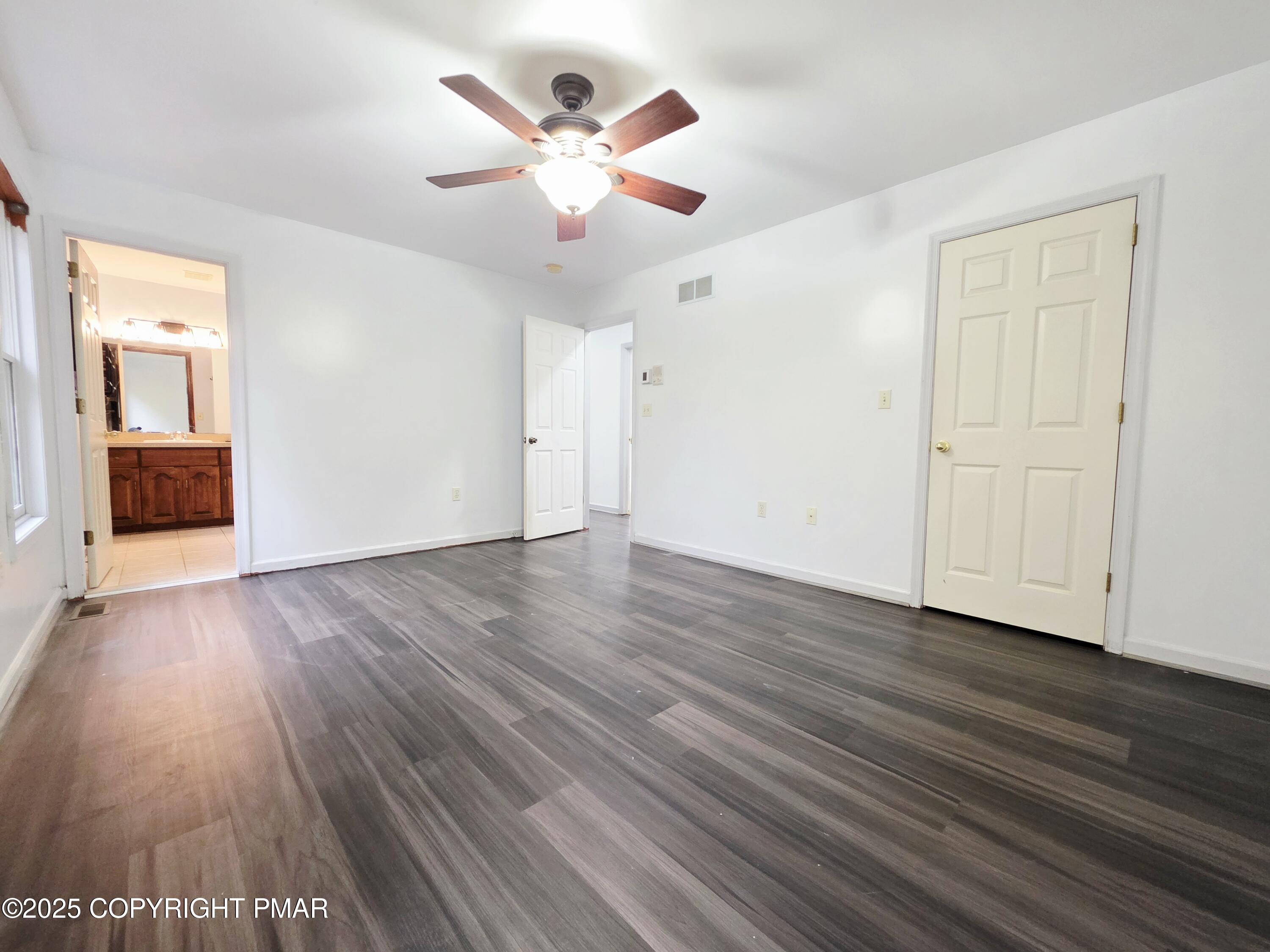 1001 Long Lake Road Tamiment, PA 18371 - Photo 19 of 38 an empty room with wooden floor and windows