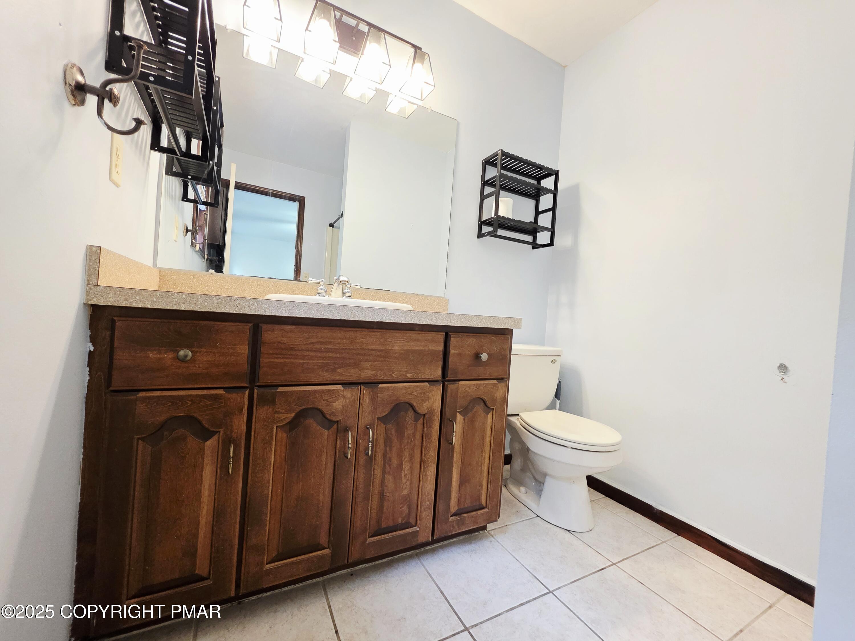 1001 Long Lake Road Tamiment, PA 18371 - Photo 21 of 38 a bathroom with a toilet a sink and mirror