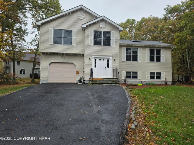 a view of a white house with a yard