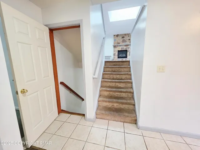 a view of an empty room with window and fireplace
