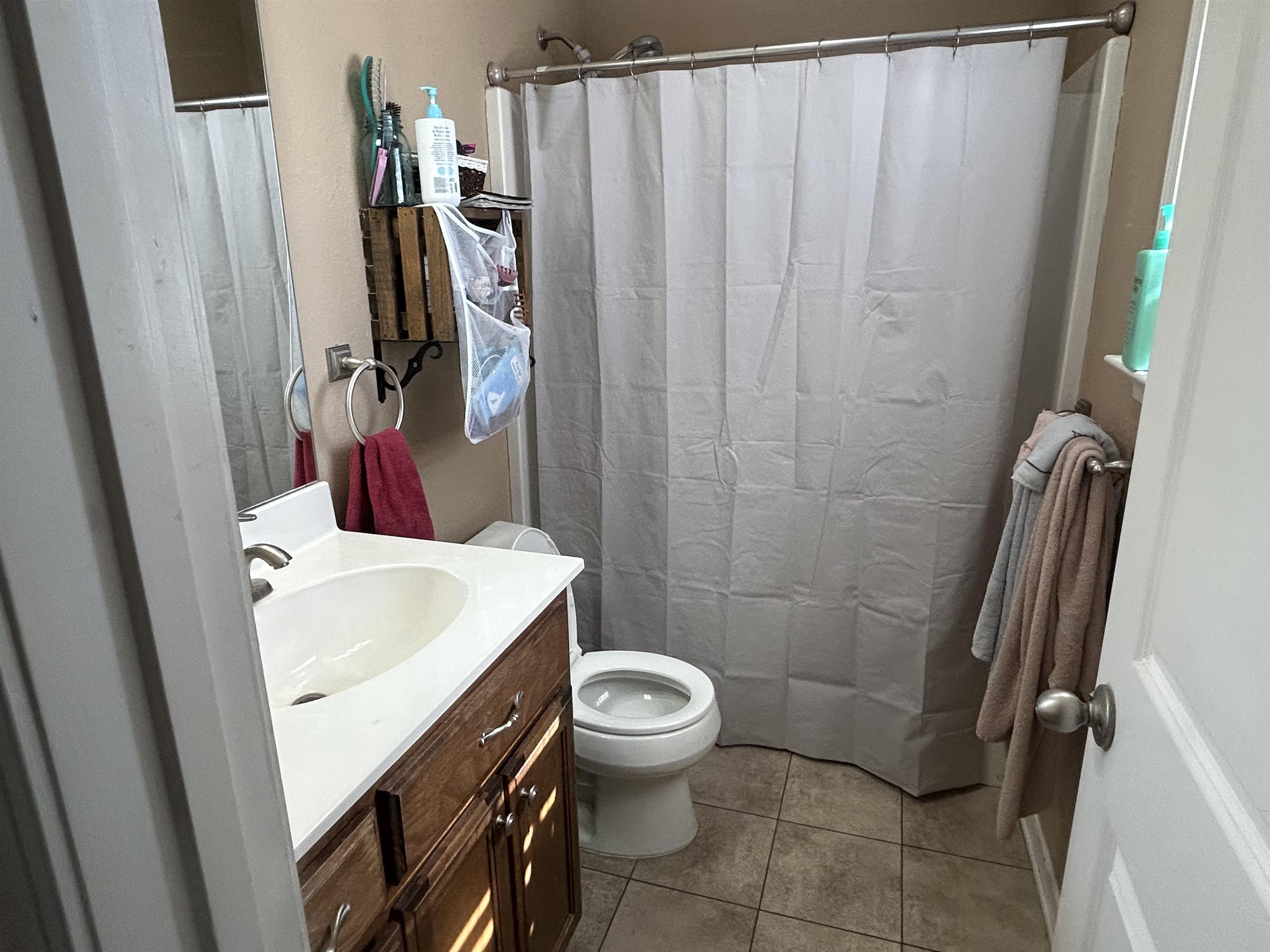 1535 Roane Street Covington, TN 38019 - Photo 12 of 25 Full bath featuring vanity, a shower with curtain, and light tile patterned floors