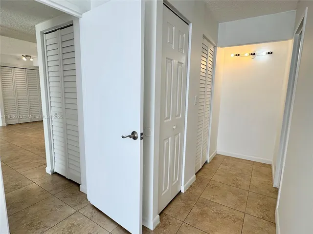 a view of a hallway with wooden cabinets