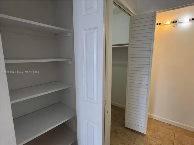 a view of walk in closet with empty racks