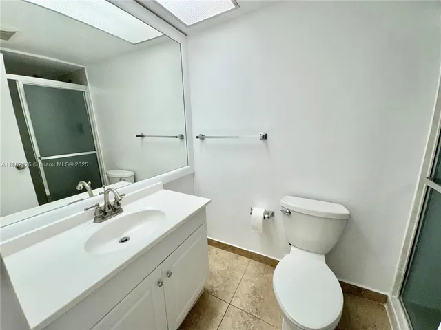 a bathroom with a sink mirror vanity and toilet