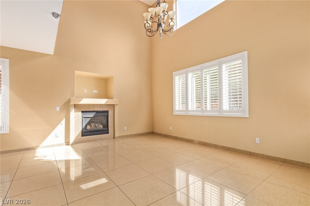 1477 Rancho Ridge Drive Henderson, NV 89012 - Photo 11 of 46 A spacious, naturally illuminated room featuring high ceilings and a cozy fireplace.