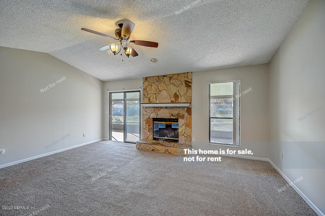 8864 Cherry Hill Drive Jacksonville, FL 32221 - Photo 11 of 17 a view of a livingroom with a fireplace a chandelier and windows
