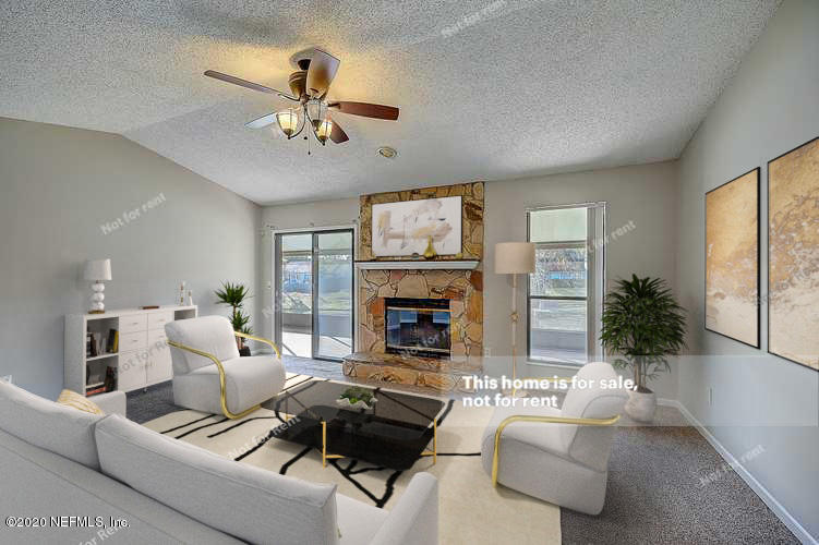 8864 Cherry Hill Drive Jacksonville, FL 32221 - Photo 2 of 17 a living room with furniture fireplace and a large window