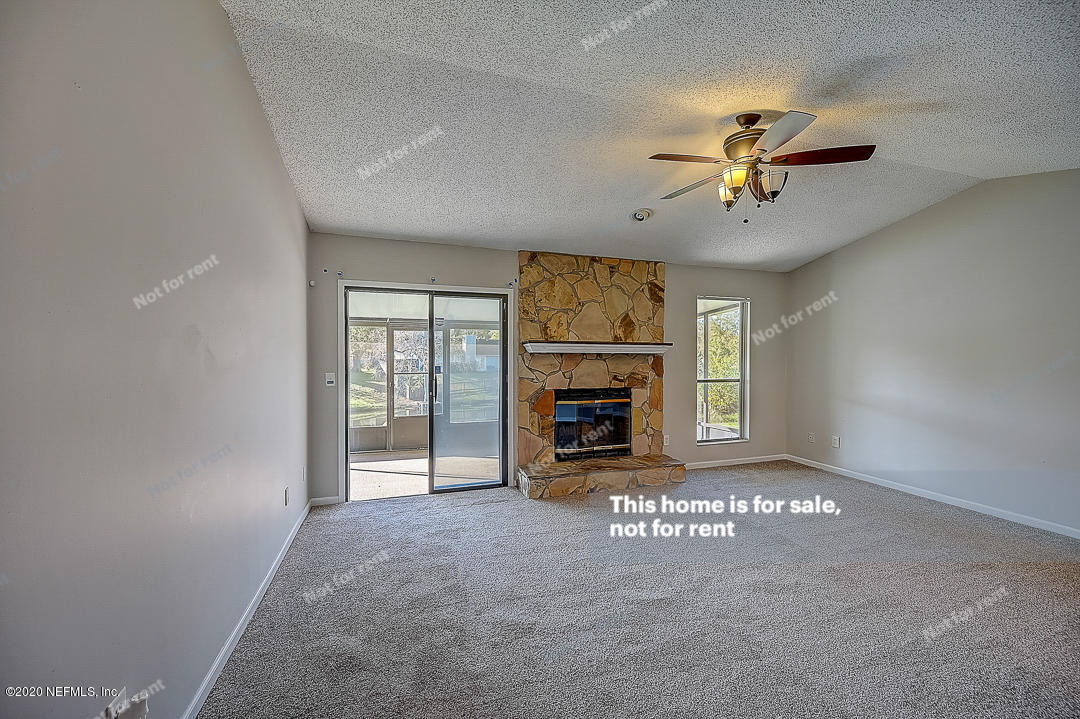 8864 Cherry Hill Drive Jacksonville, FL 32221 - Photo 4 of 17 a view of an empty room with a fireplace and a window