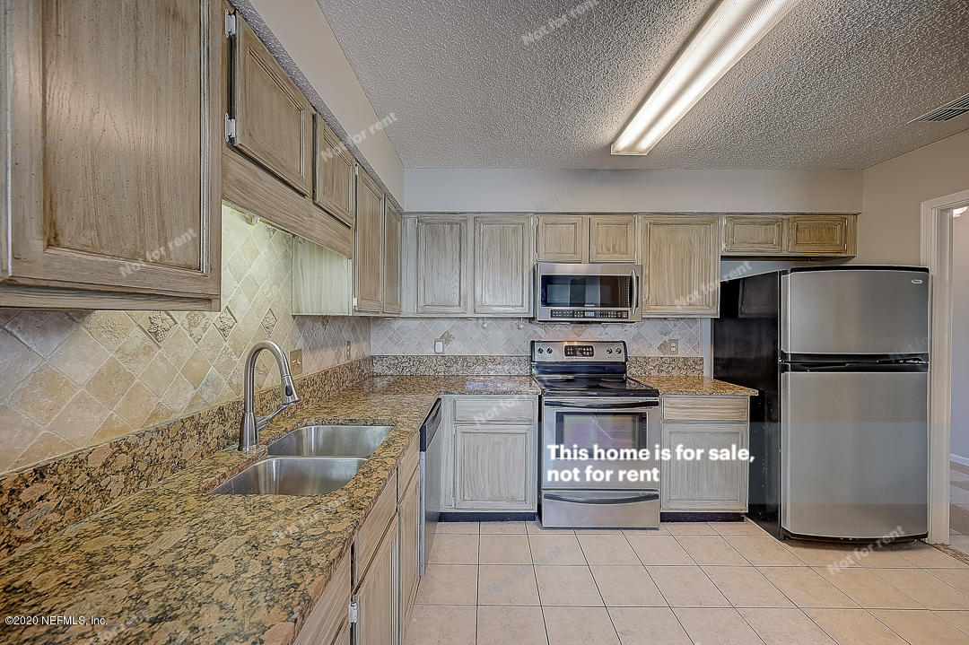 8864 Cherry Hill Drive Jacksonville, FL 32221 - Photo 5 of 17 a kitchen with stainless steel appliances granite countertop a refrigerator a stove a sink and a granite counter tops