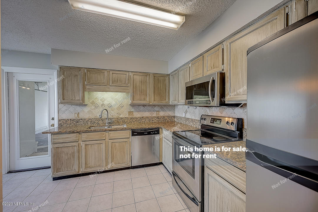 8864 Cherry Hill Drive Jacksonville, FL 32221 - Photo 8 of 17 a kitchen with stainless steel appliances a sink stove and microwave