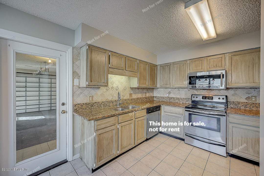 8864 Cherry Hill Drive Jacksonville, FL 32221 - Photo 9 of 17 a kitchen with stainless steel appliances granite countertop a stove sink and cabinets