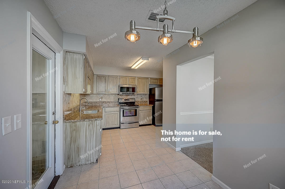 8864 Cherry Hill Drive Jacksonville, FL 32221 - Photo 10 of 17 a view of a kitchen with refrigerator and cabinets