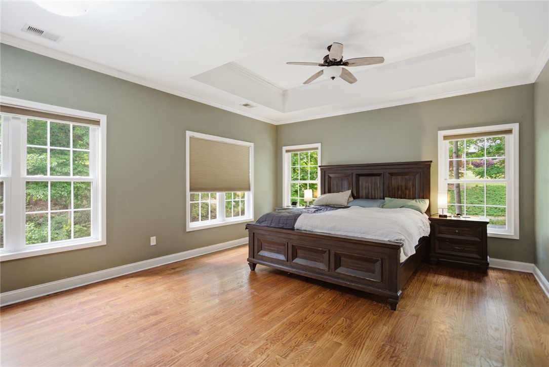 207 Devonhurst Drive Seneca, SC 29678 - Photo 18 of 50 Primary Bedroom on Upper Level. This spacious room features ample natural light, tray ceiling and warm wood flooring.
