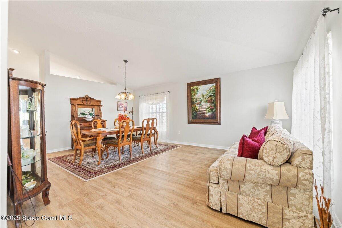 1404 Boca Rio Drive Melbourne, FL 32940 - Photo 13 of 53 a living room with furniture and a chandelier