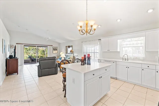 a kitchen with stainless steel appliances granite countertop a refrigerator a sink dishwasher a dining table and chairs with wooden floor