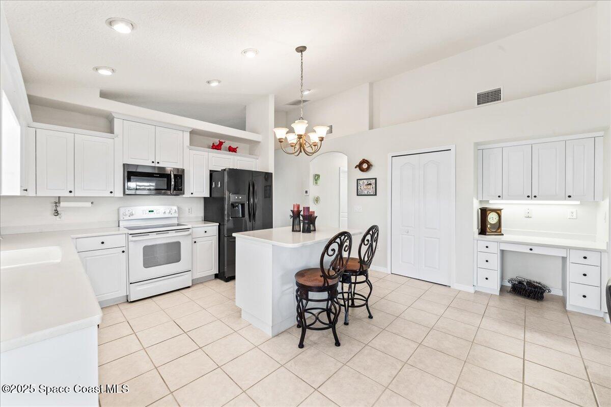 1404 Boca Rio Drive Melbourne, FL 32940 - Photo 18 of 53 a kitchen with a white cabinets and chairs