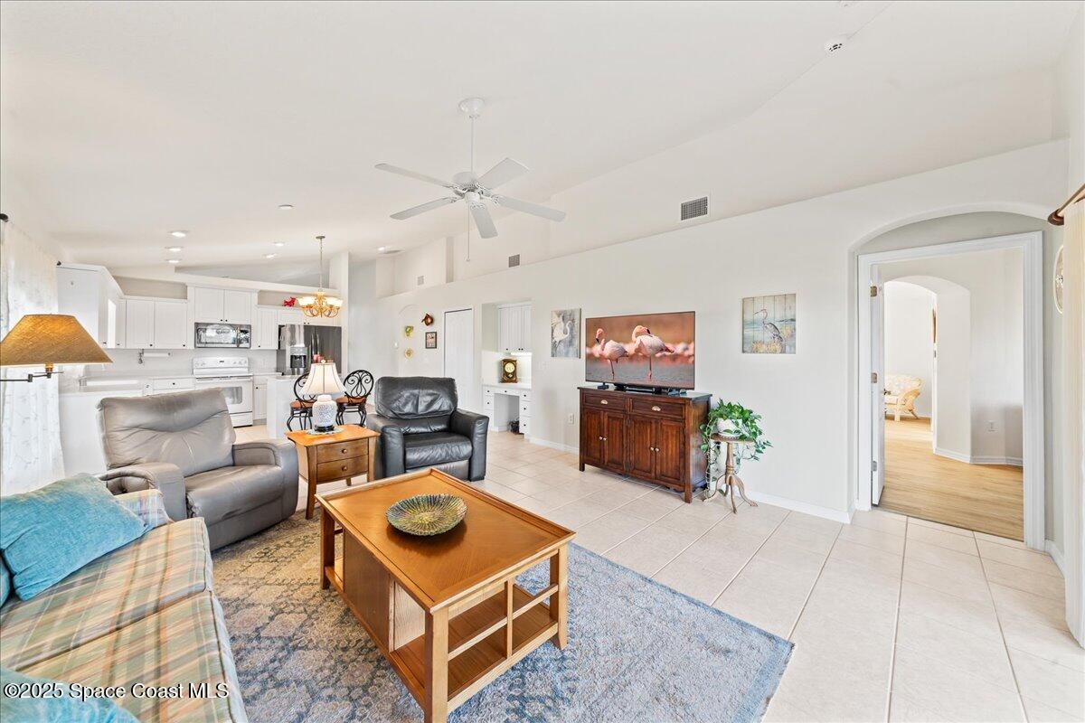 1404 Boca Rio Drive Melbourne, FL 32940 - Photo 23 of 53 a living room with furniture a table and kitchen view