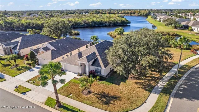 an aerial view of a house with a yard and lake view