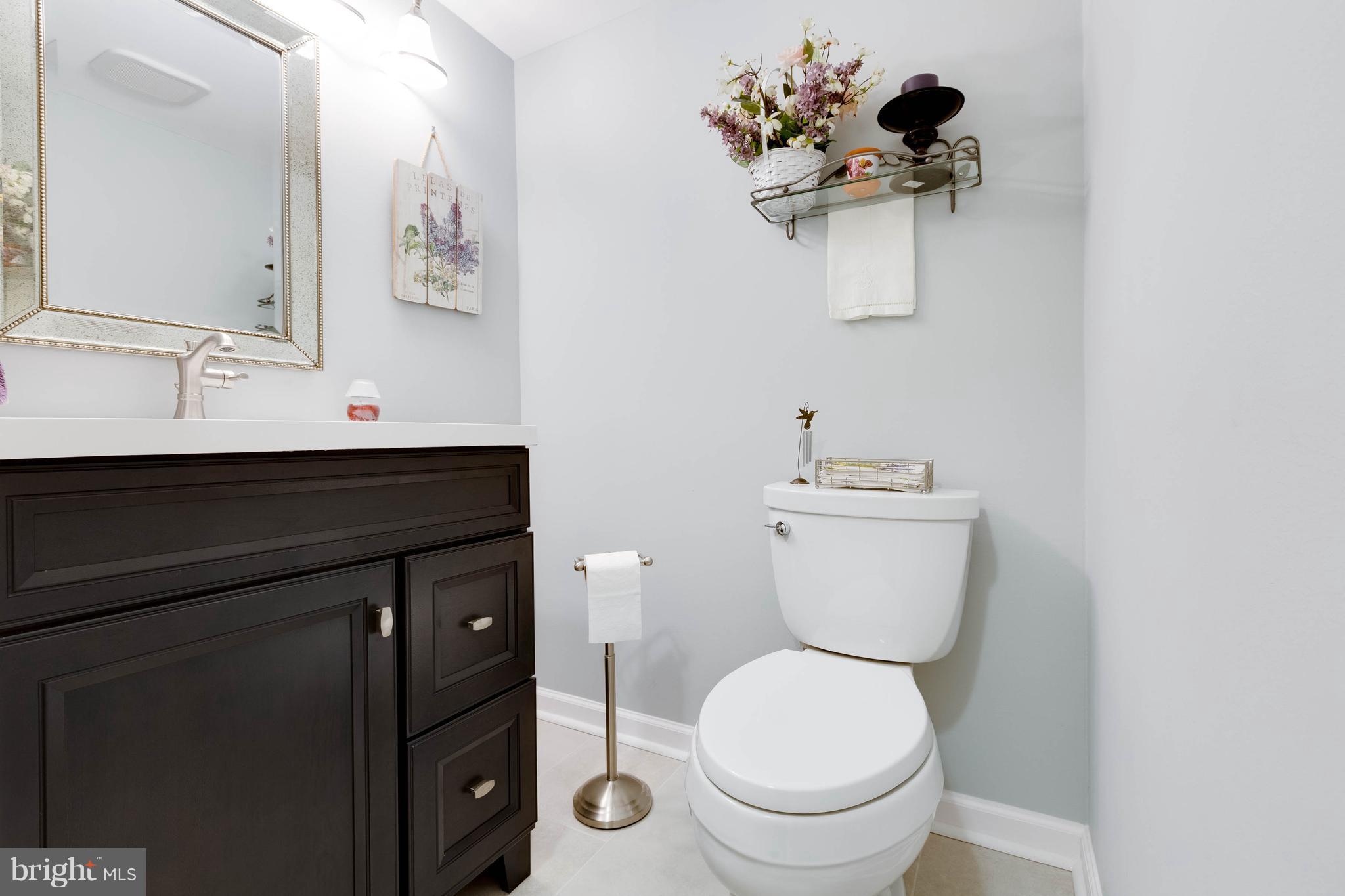 11204 Chestnut Grove Square, Unit 305 Reston, VA 20190 - Photo 8 of 21 a bathroom with a toilet sink and mirror