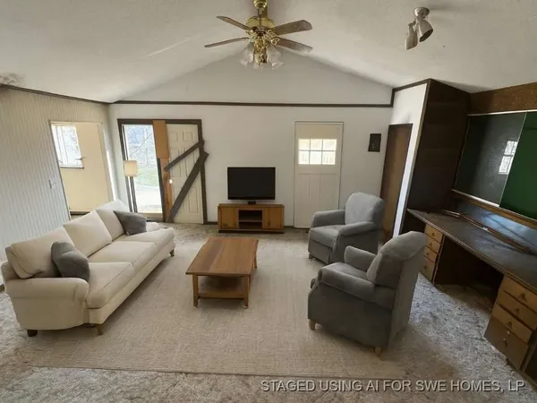 a living room with furniture a flat screen tv and a window