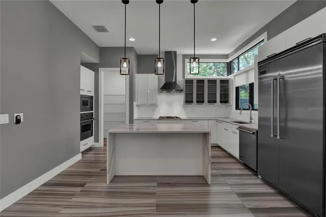 a kitchen with stainless steel appliances granite countertop a refrigerator a sink and a stove