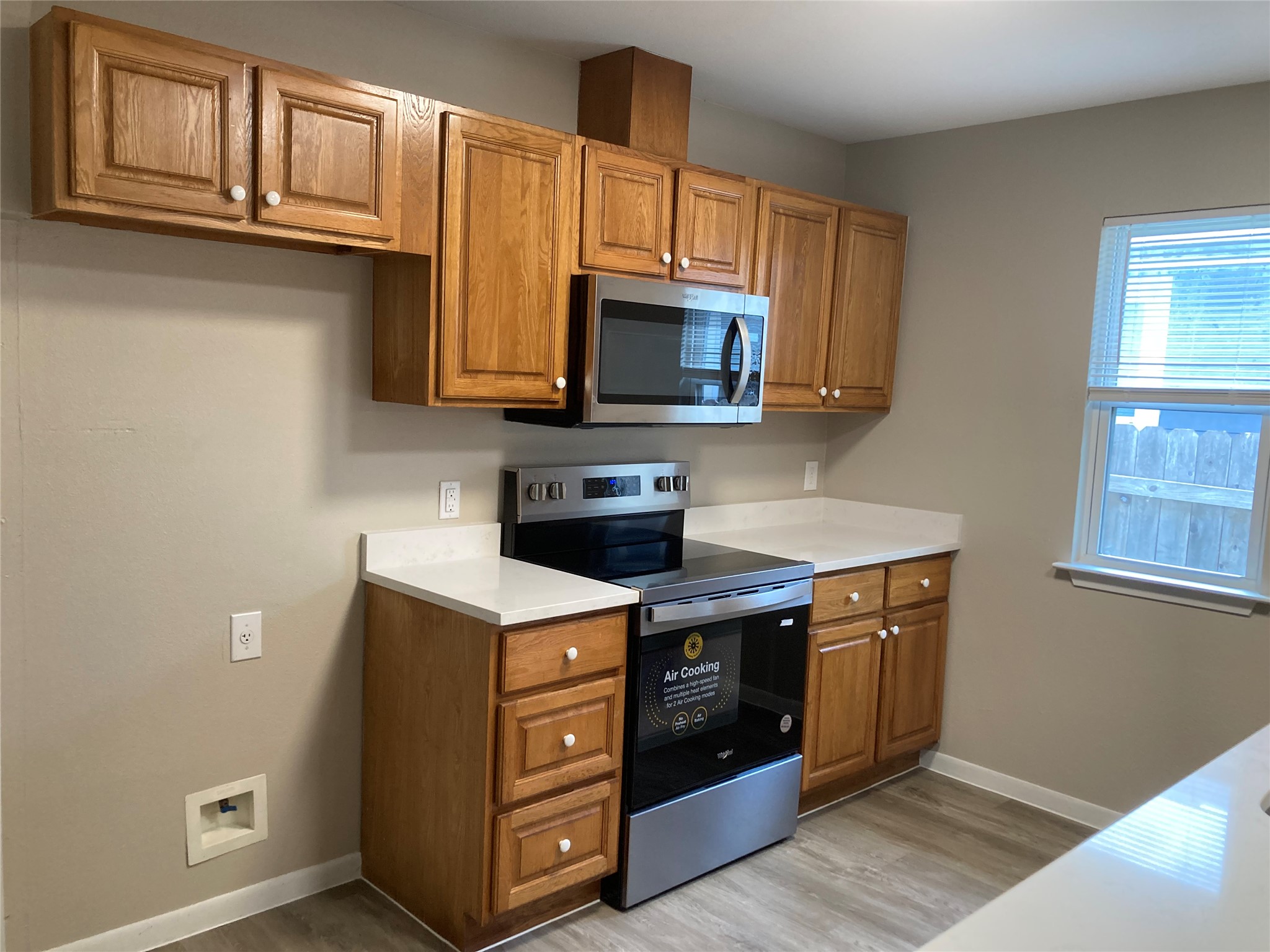 7307 Thannas Way Austin, TX 78744 - Photo 2 of 13 Kitchen featuring stainless steel appliances, wood finish cabinets, light countertops, and light wood-style flooring