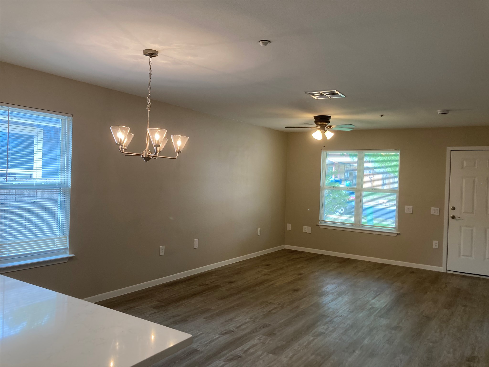 7307 Thannas Way Austin, TX 78744 - Photo 3 of 13 Unfurnished dining area with dark wood-style floors, suspended lighting, and a ceiling fan