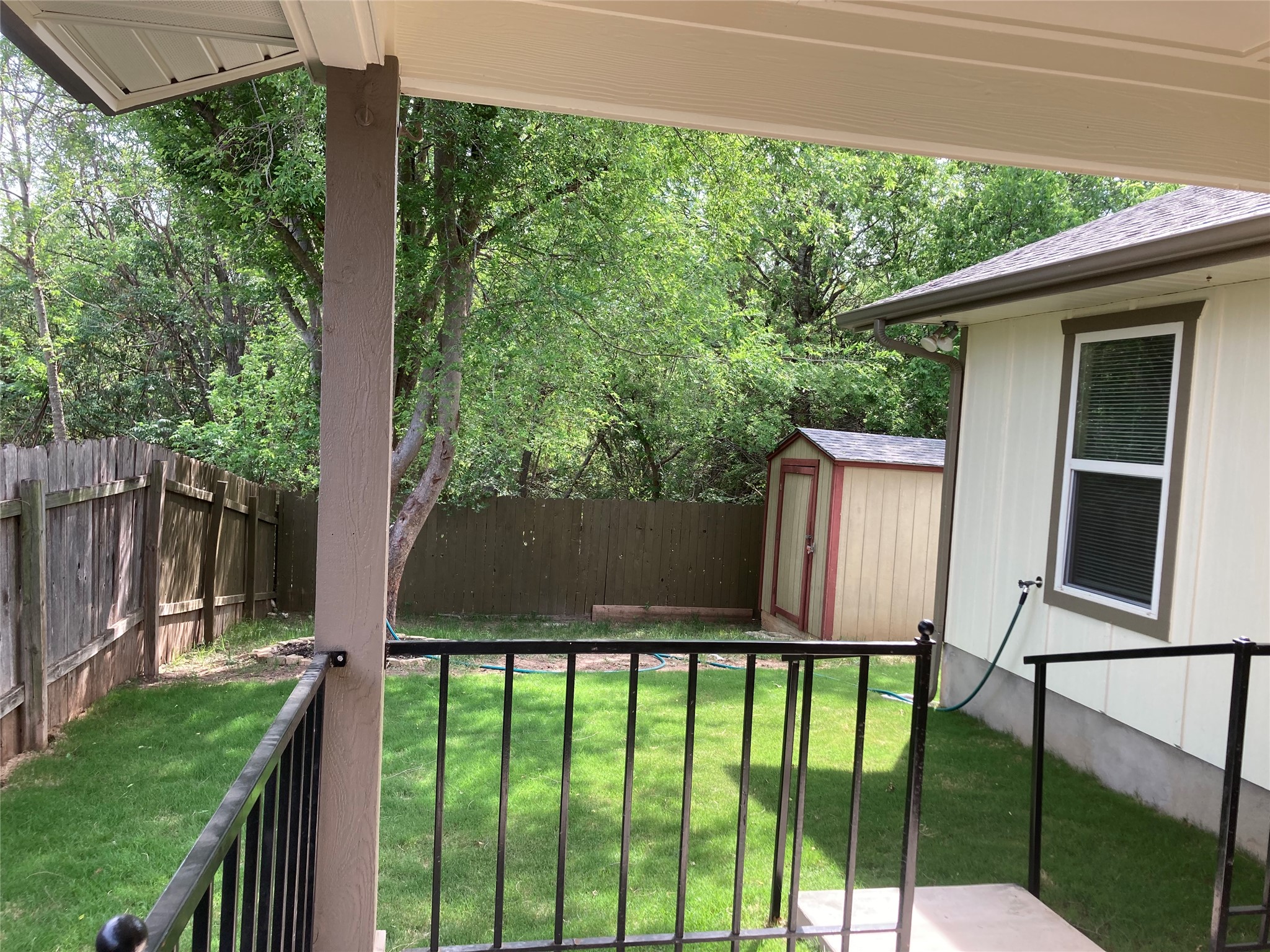 7307 Thannas Way Austin, TX 78744 - Photo 7 of 13 Fenced backyard featuring a storage unit