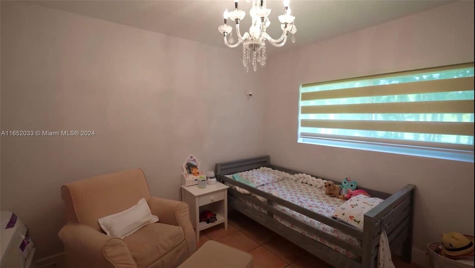 11866 Southwest 43rd Street Miami, FL 33175 - Photo 14 of 64 a bedroom with a bed and a chandelier