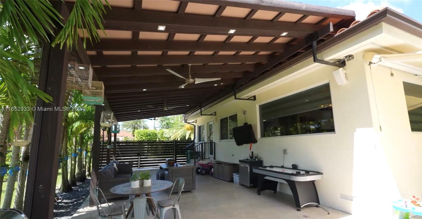 11866 Southwest 43rd Street Miami, FL 33175 - Photo 16 of 64 a view of a patio with table and chairs with wooden floor and fence