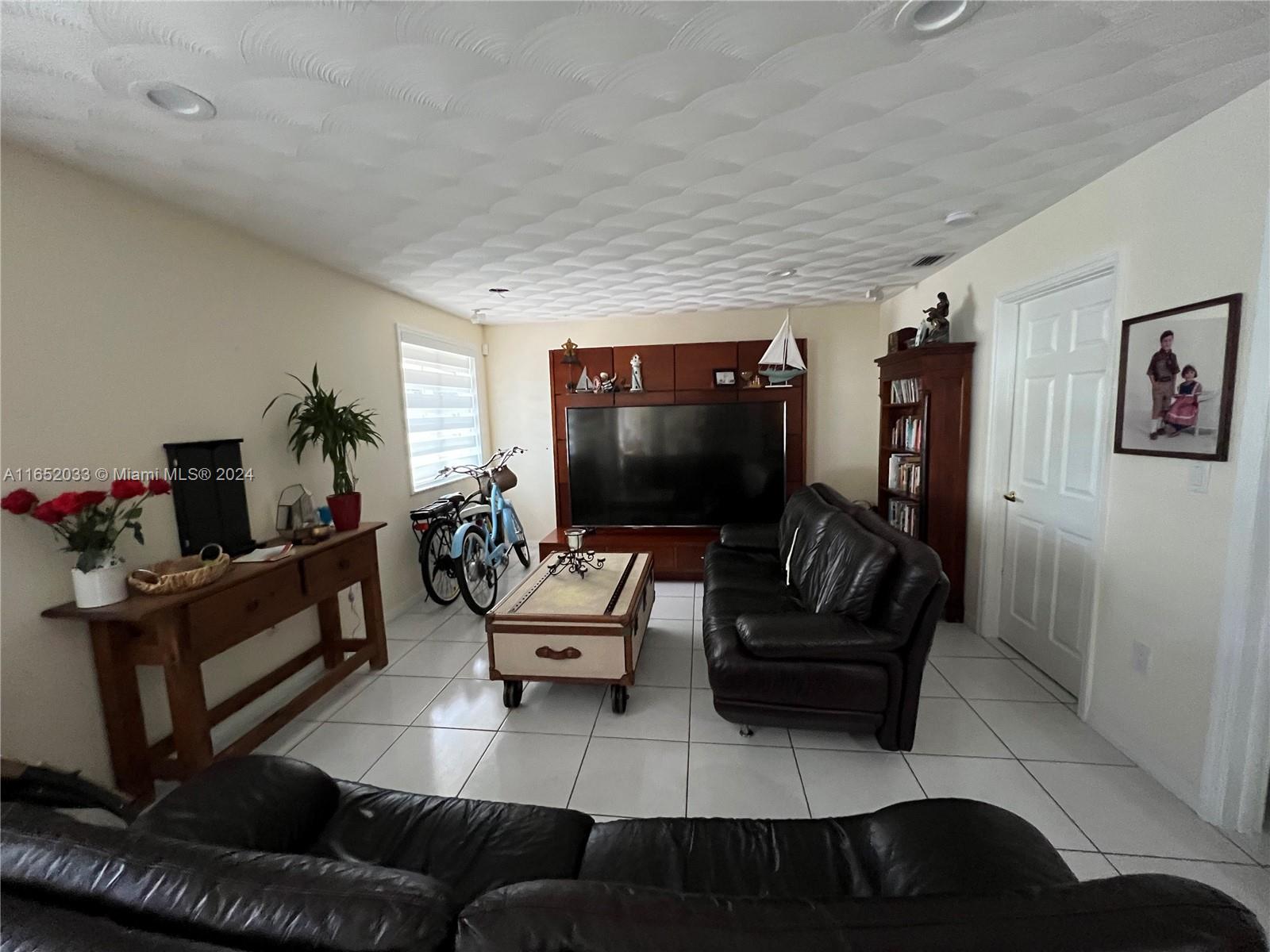11866 Southwest 43rd Street Miami, FL 33175 - Photo 31 of 64 a living room with furniture and a flat screen tv
