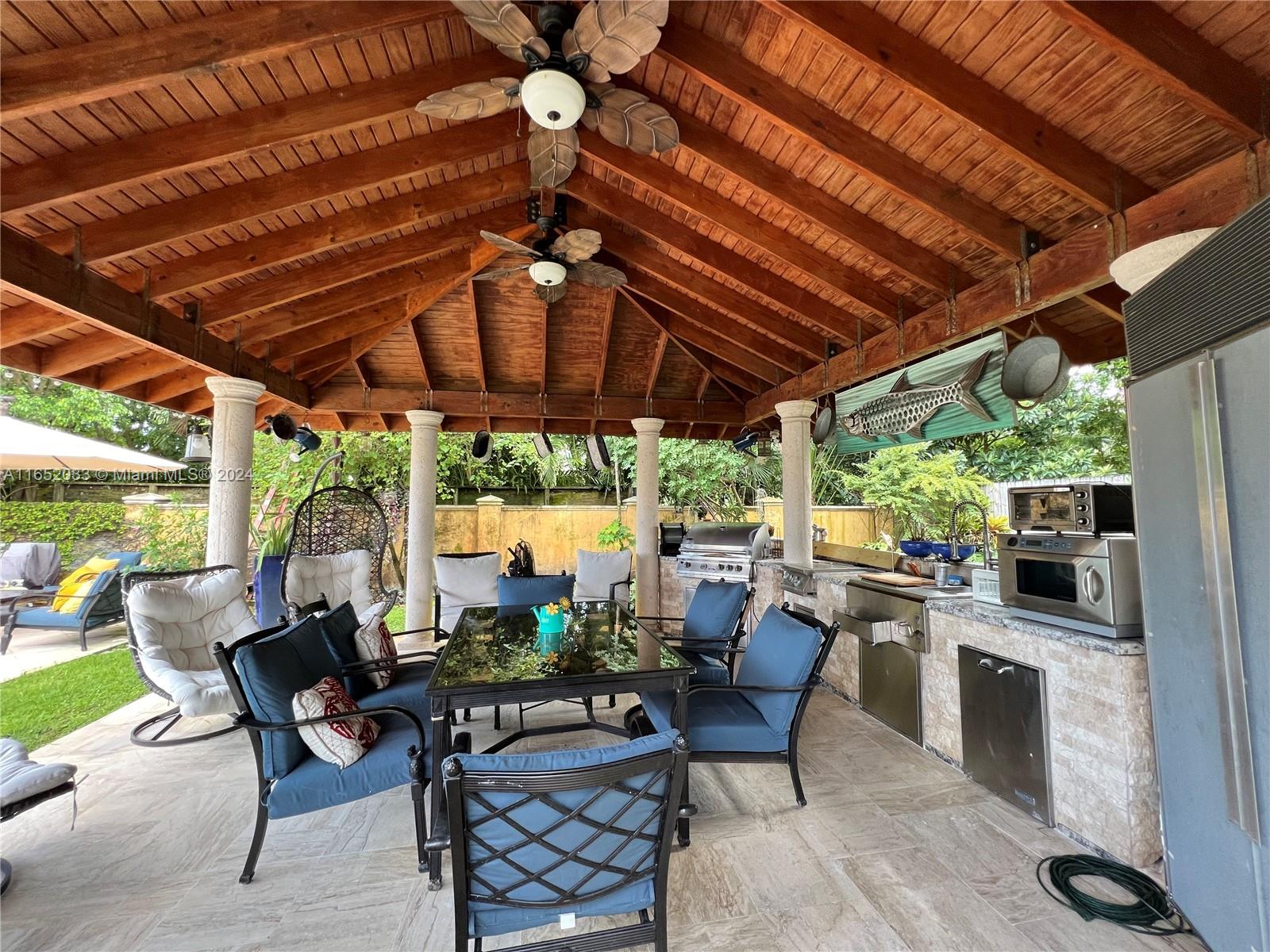 11866 Southwest 43rd Street Miami, FL 33175 - Photo 55 of 64 a patio with a patio table and chairs with a barbeque grill