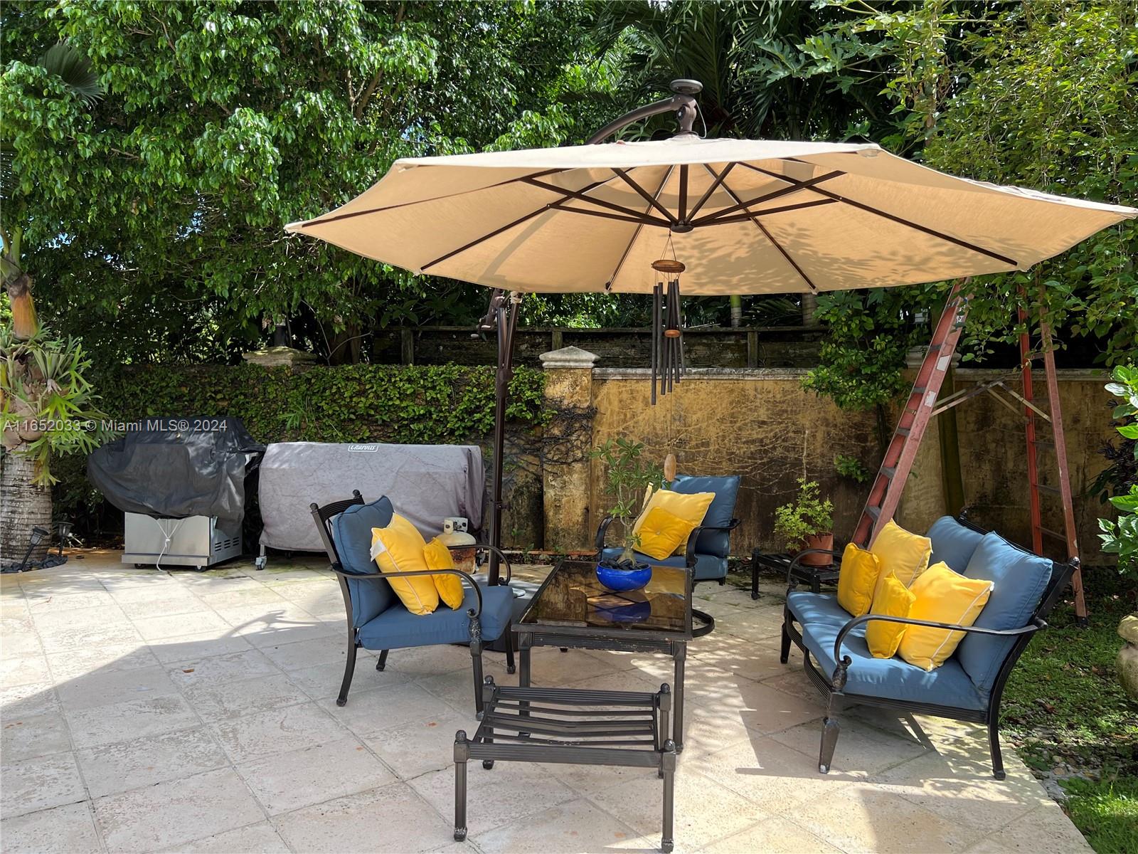 11866 Southwest 43rd Street Miami, FL 33175 - Photo 58 of 64 a view of an outdoor sitting area with chairs and umbrella