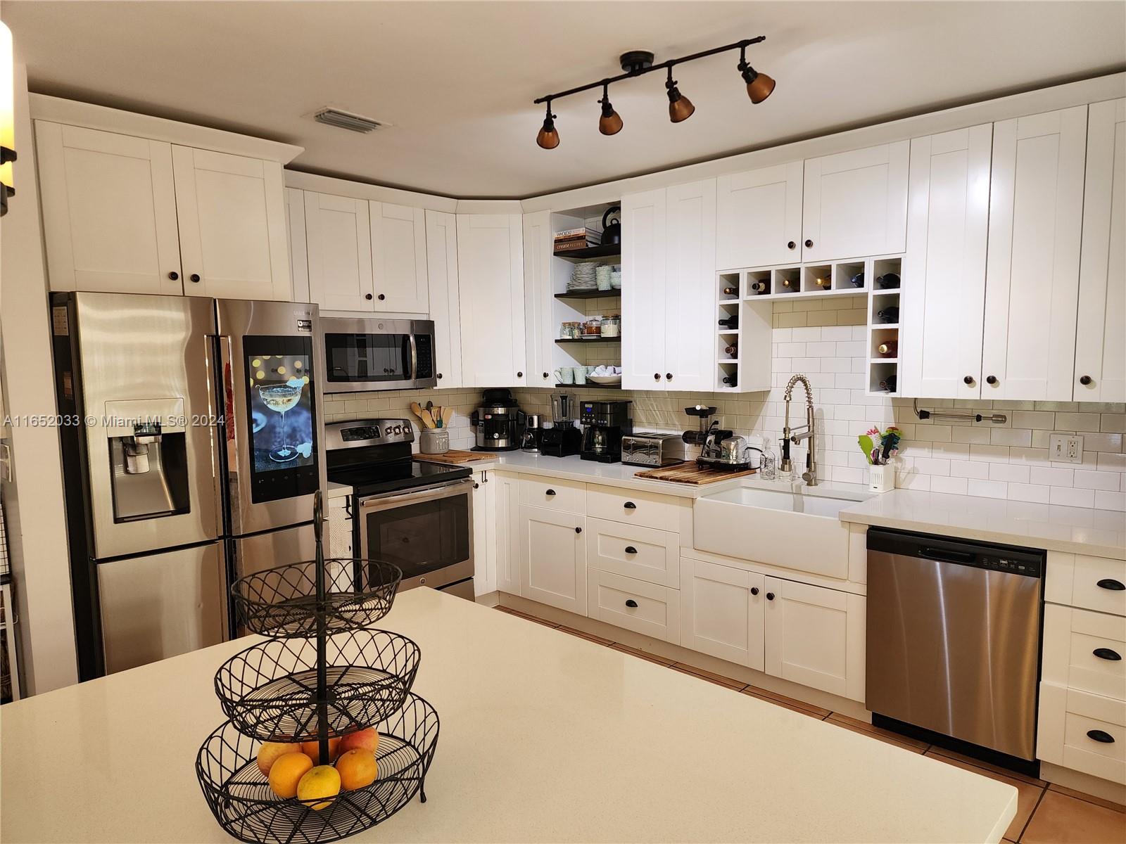11866 Southwest 43rd Street Miami, FL 33175 - Photo 10 of 64 a kitchen with stainless steel appliances a refrigerator sink and cabinets