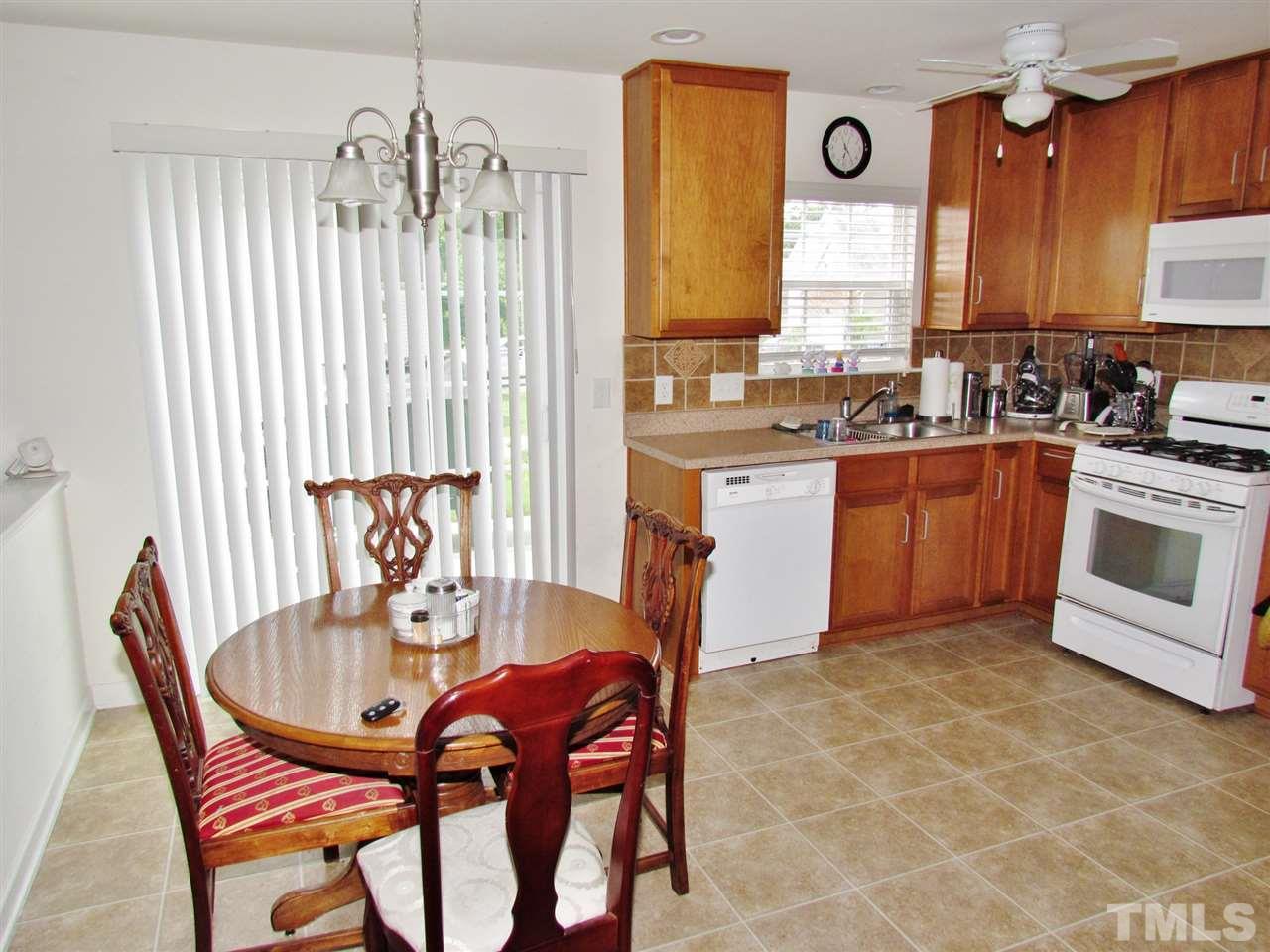 5200 Chasteal Trail Raleigh, NC 27610 - Photo 10 of 25 a kitchen with stainless steel appliances granite countertop a stove a sink dishwasher a dining table and chairs with wooden floor