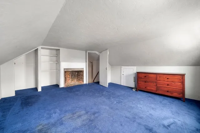 a view of an empty room with a fireplace and a window