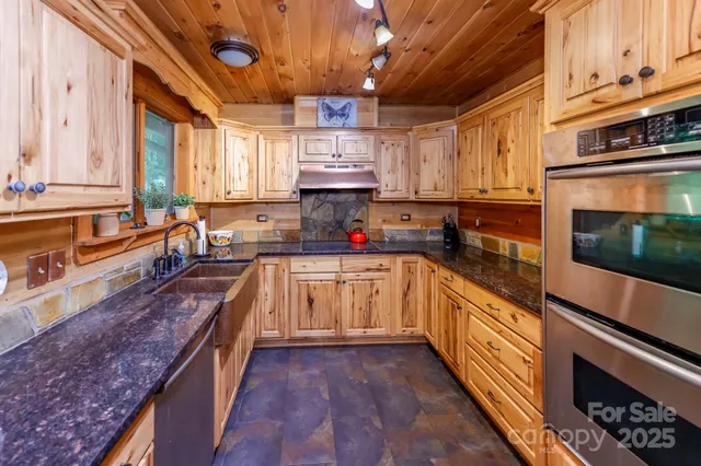 a kitchen with stainless steel appliances granite countertop a stove a sink and a microwave