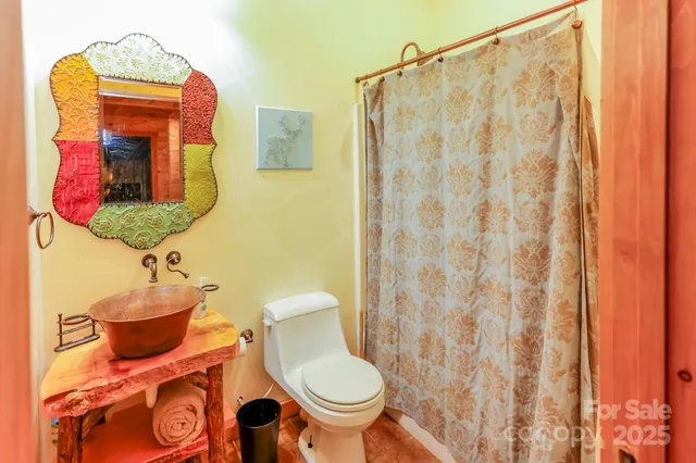 a bathroom with a toilet and a shower curtain