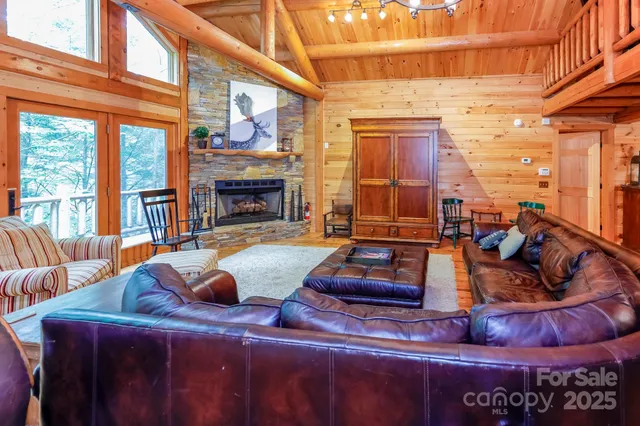 a living room with furniture a fireplace and floor to ceiling windows