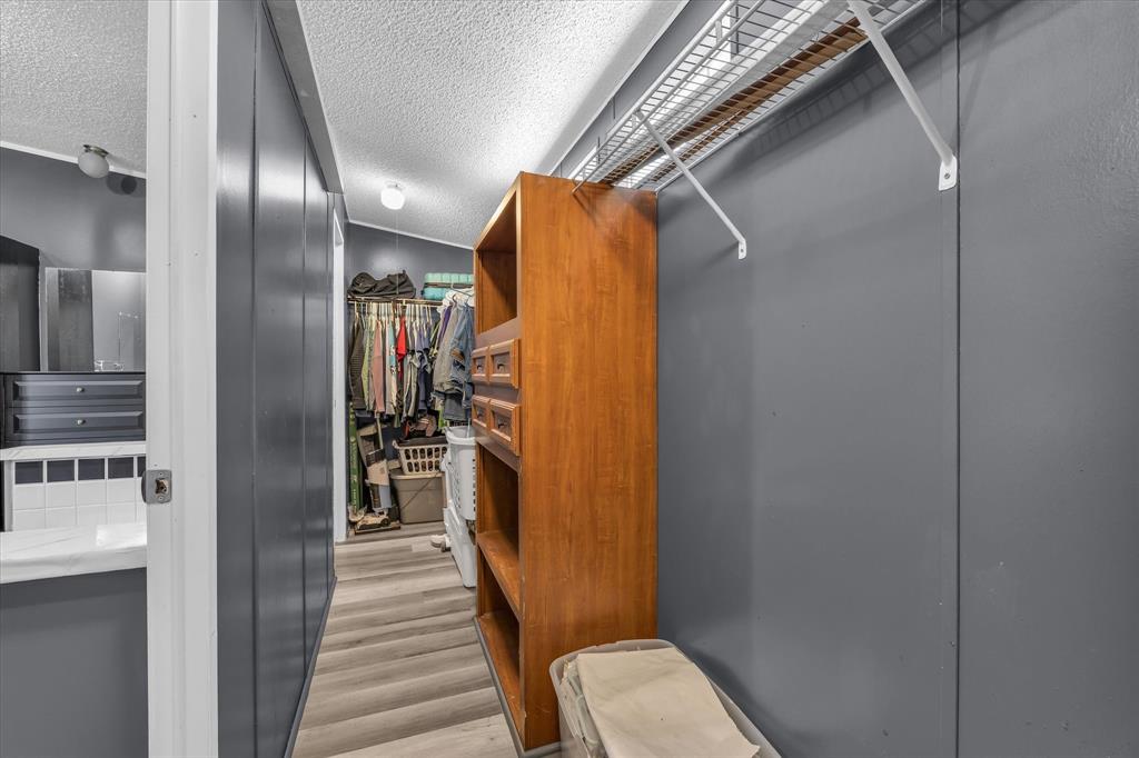 3615 Spring Valley Road Lorena, TX 76655 - Photo 17 of 33 Walk-in closet featuring wire shelving, built-in wooden storage, and wood-finish flooring