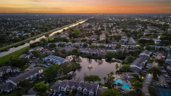 an aerial view of house with yard and lake view in back