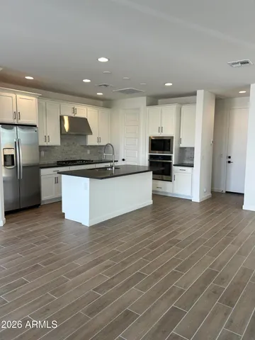 a kitchen with stainless steel appliances granite countertop a sink and a stove